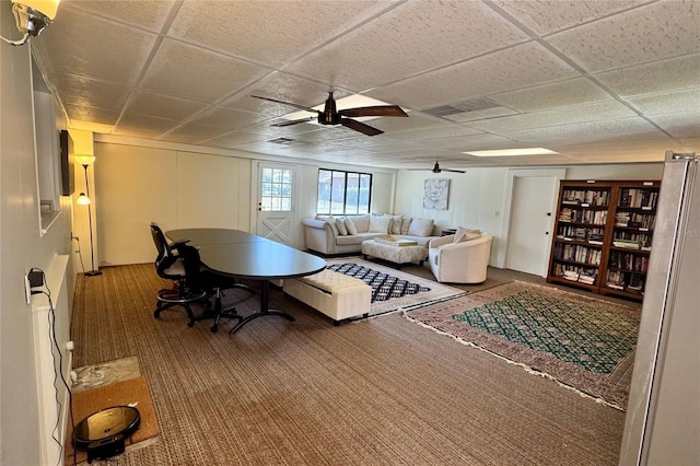 living area with carpet floors, a paneled ceiling, and a ceiling fan