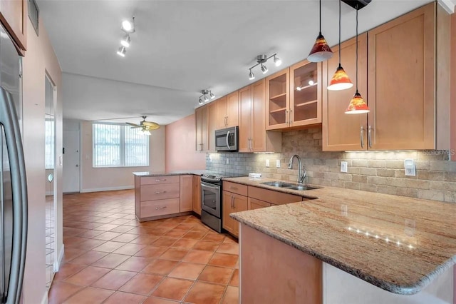 kitchen with decorative backsplash, appliances with stainless steel finishes, glass insert cabinets, a sink, and a peninsula