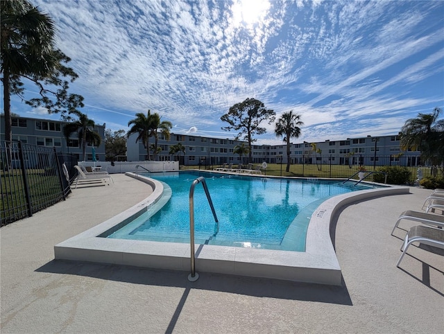 pool with a patio area and fence