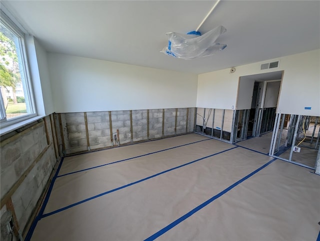 unfurnished room with concrete floors and visible vents