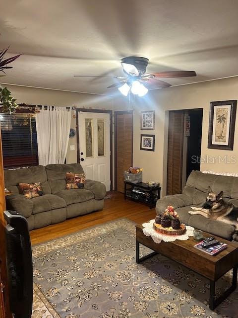 living room featuring a ceiling fan and wood finished floors