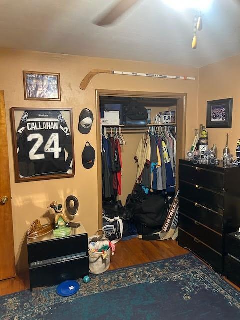 bedroom featuring ceiling fan, a closet, and wood finished floors