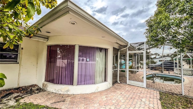 doorway to property featuring stucco siding and a patio