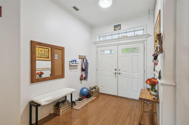 entrance foyer featuring ornamental molding, wood-type flooring, and visible vents