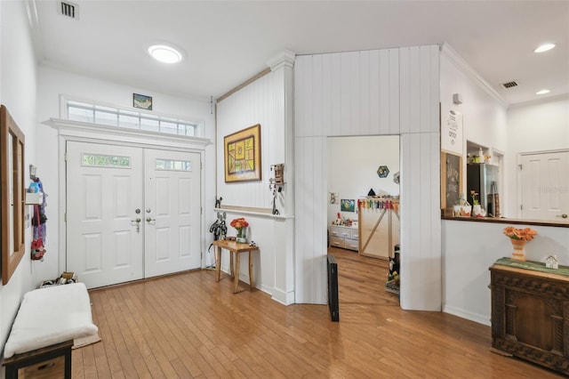 entryway with recessed lighting, wood-type flooring, visible vents, and crown molding