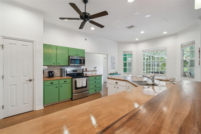 kitchen with appliances with stainless steel finishes, visible vents, green cabinetry, and wood counters