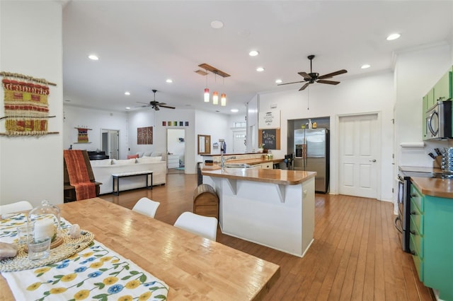 kitchen featuring stainless steel appliances, a sink, light wood-style flooring, and recessed lighting