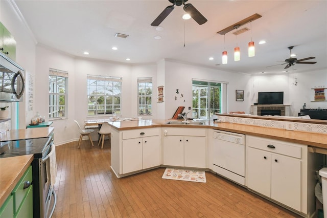 kitchen with stainless steel appliances, visible vents, white cabinets, a sink, and light wood-type flooring