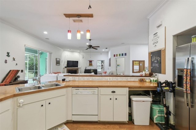 kitchen with pendant lighting, a ceiling fan, white dishwasher, a sink, and stainless steel fridge