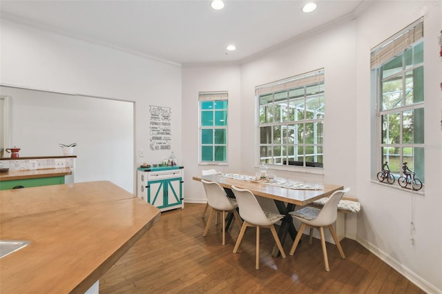 dining room with hardwood / wood-style flooring, baseboards, crown molding, and recessed lighting