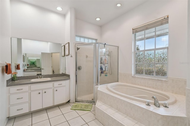 full bath featuring a garden tub, vanity, a shower stall, and tile patterned floors