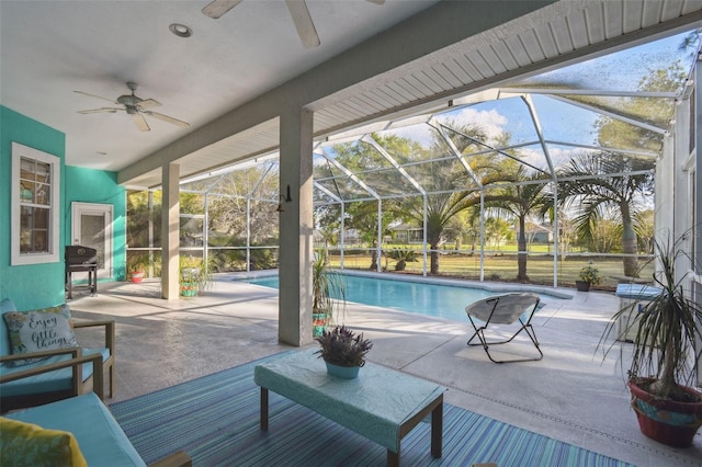 outdoor pool with a ceiling fan, glass enclosure, a patio, and outdoor lounge area