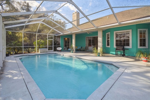 outdoor pool with glass enclosure, a patio area, a grill, and a ceiling fan