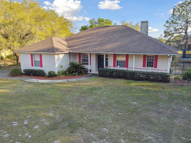 ranch-style home with covered porch, a shingled roof, a chimney, and a front yard