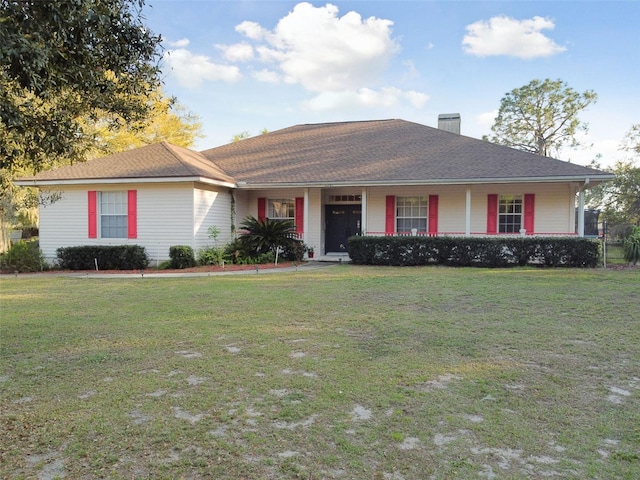 ranch-style house featuring a porch, a front yard, and a chimney