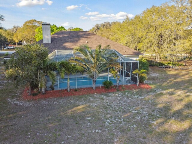 view of side of property featuring a lanai and a chimney