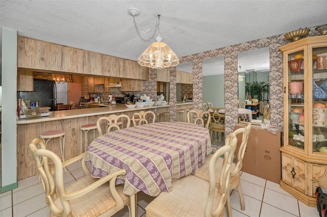 tiled dining space with an inviting chandelier and a textured ceiling