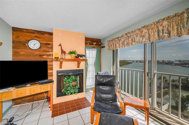 living room with light tile patterned floors, wooden walls, and a water view