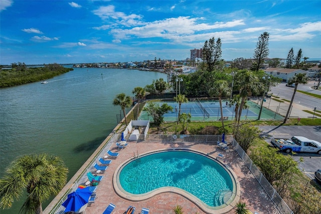 view of pool featuring a water view and a patio area