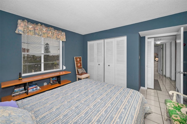 tiled bedroom featuring a textured ceiling and a closet