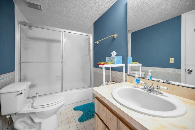 full bathroom featuring combined bath / shower with glass door, tile patterned flooring, vanity, toilet, and a textured ceiling