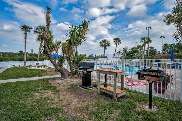 exterior space featuring a water view, a pool, and a yard