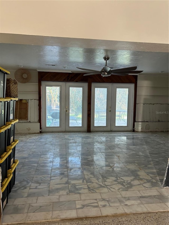 unfurnished living room with french doors and ceiling fan