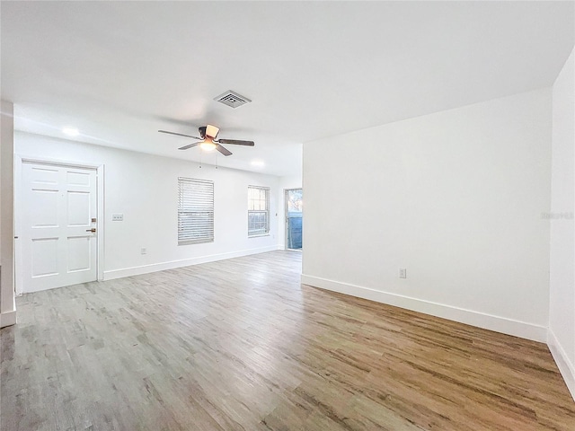 unfurnished living room with baseboards, visible vents, and wood finished floors