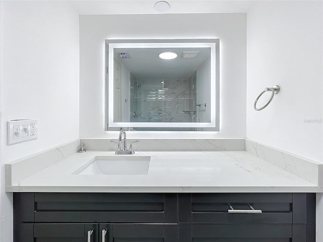 full bath featuring visible vents, vanity, and a marble finish shower