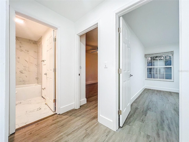 hallway with light wood-style floors and baseboards