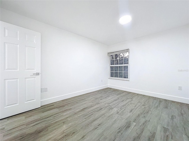 empty room with light wood-type flooring and baseboards