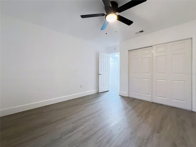 unfurnished bedroom with visible vents, baseboards, a ceiling fan, dark wood finished floors, and a closet