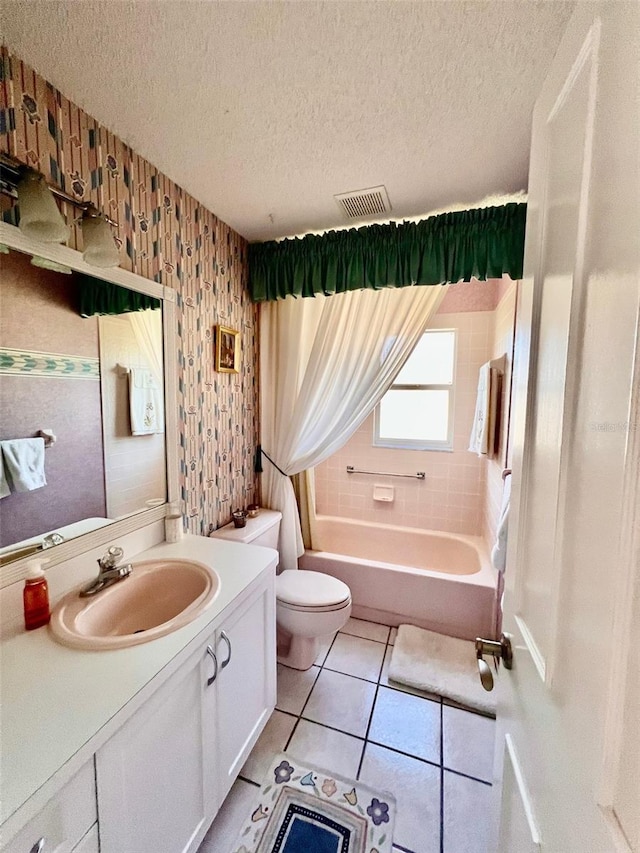 full bathroom with tile patterned flooring, vanity, a textured ceiling, and toilet