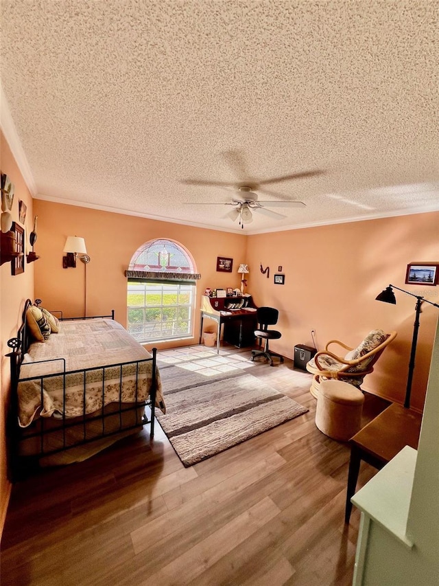 bedroom featuring crown molding, ceiling fan, wood-type flooring, and a textured ceiling