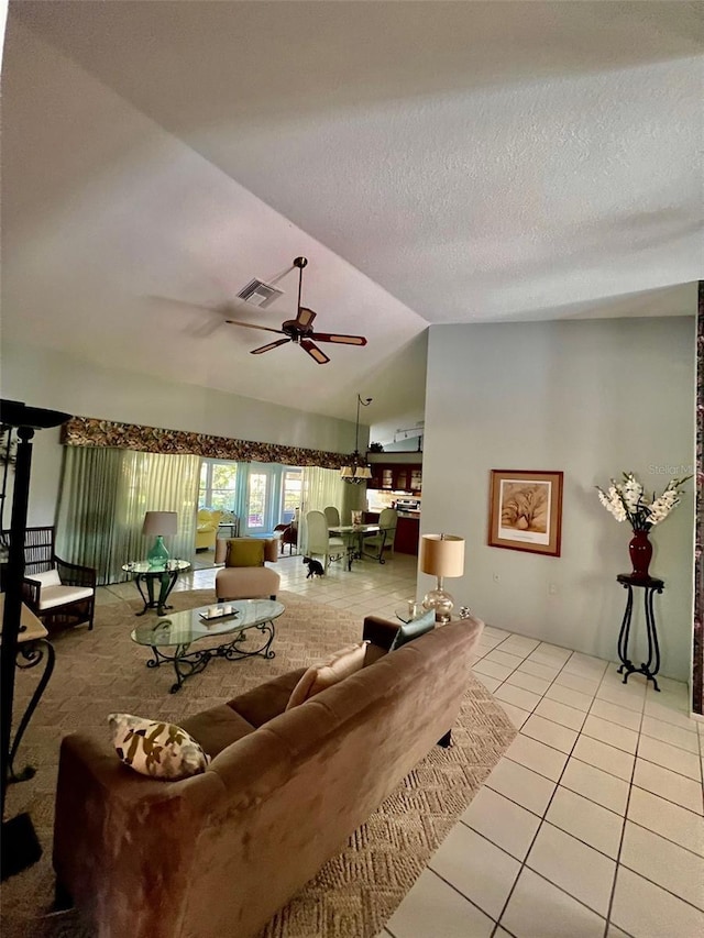 tiled living room featuring a textured ceiling, vaulted ceiling, and ceiling fan