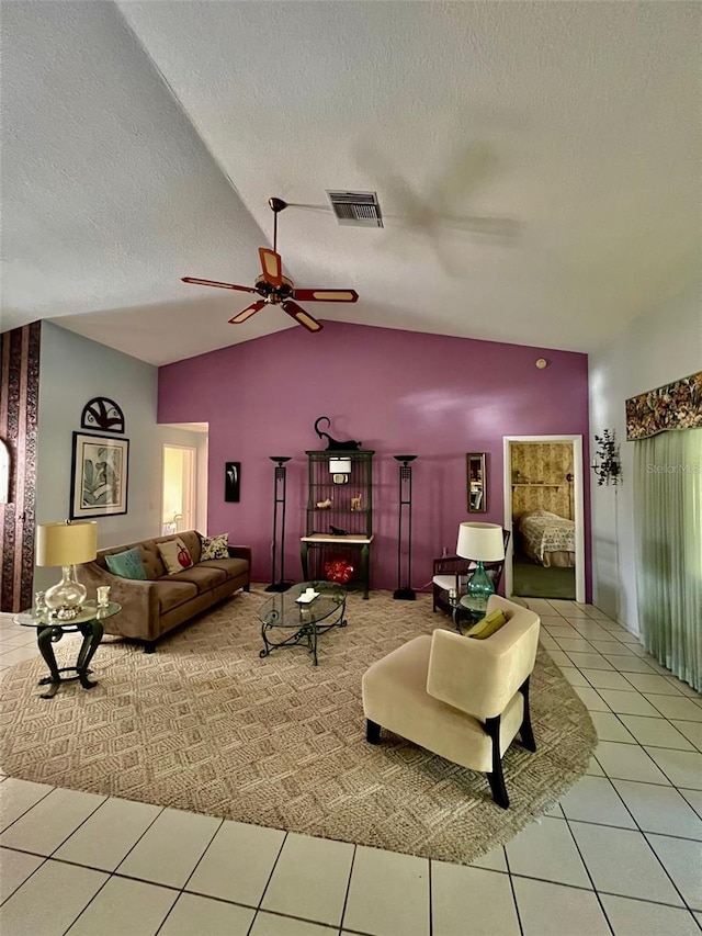 tiled living room with ceiling fan, lofted ceiling, and a textured ceiling