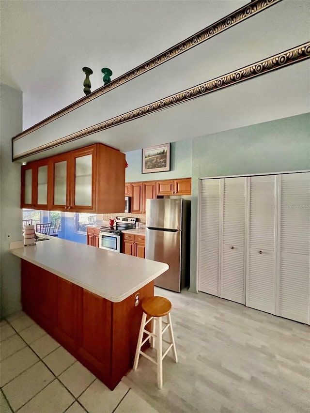 kitchen featuring a breakfast bar area, kitchen peninsula, and appliances with stainless steel finishes