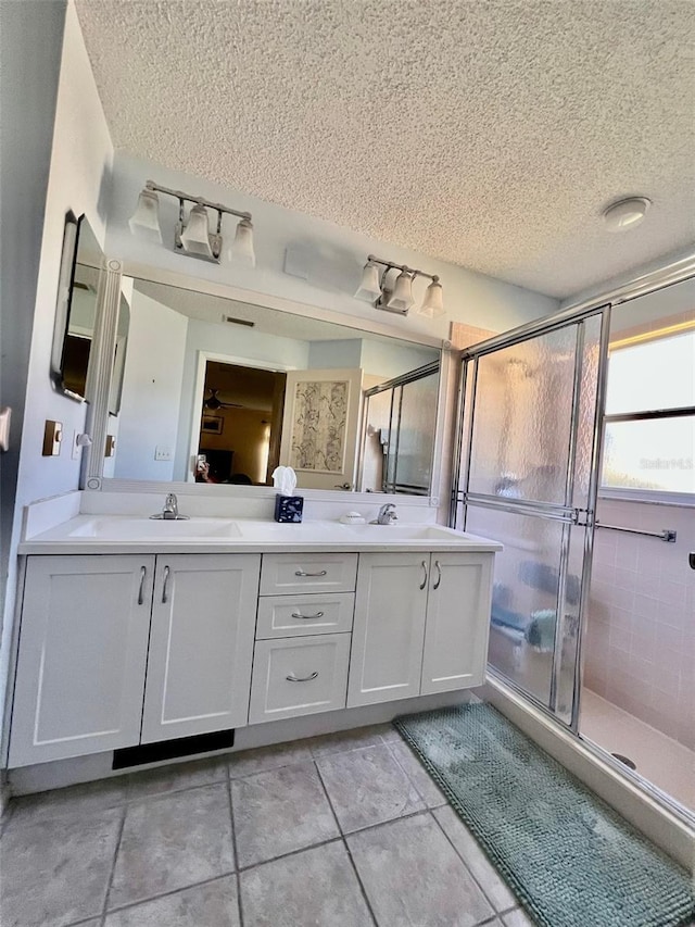 bathroom featuring vanity, an enclosed shower, tile patterned flooring, and a textured ceiling