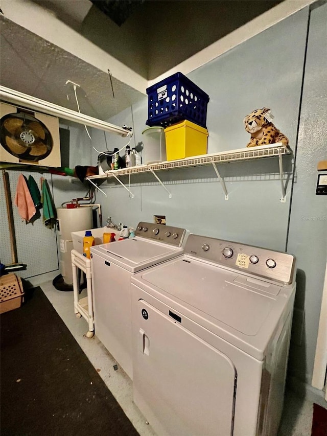 clothes washing area featuring washer and clothes dryer and water heater