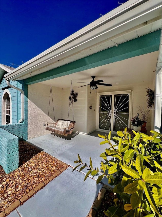 entrance to property featuring ceiling fan and a patio area