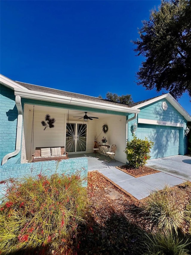 view of front of property featuring ceiling fan, a garage, and covered porch