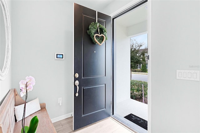 foyer featuring light wood finished floors and baseboards