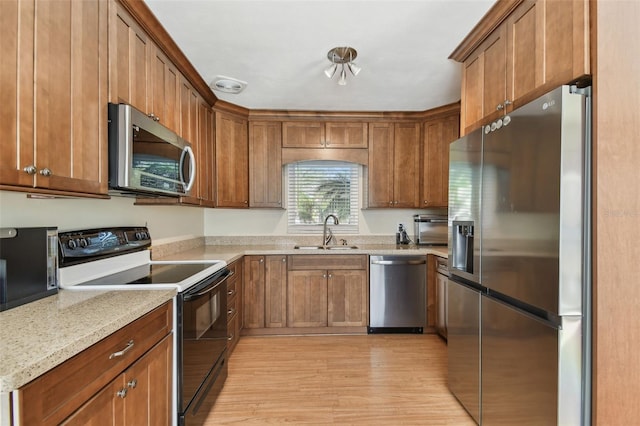 kitchen with stainless steel appliances, brown cabinets, and a sink