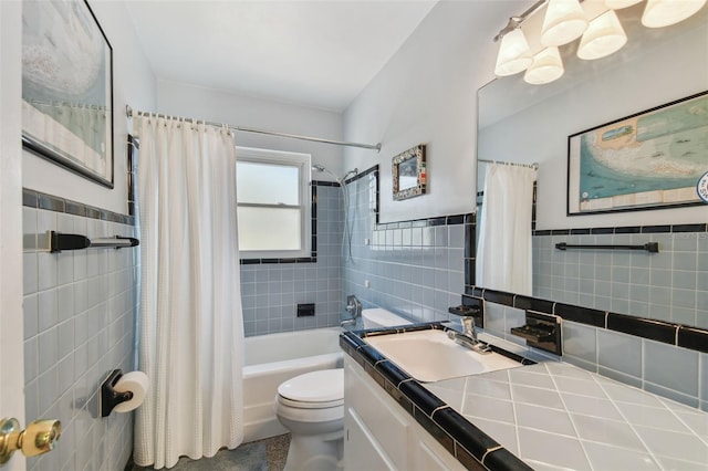 bathroom with a wainscoted wall, tile walls, shower / bathtub combination with curtain, toilet, and vanity