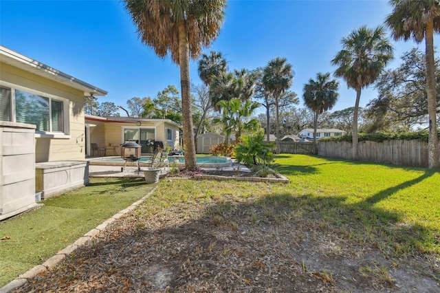 view of yard with a patio area, a shed, fence, and a fenced in pool