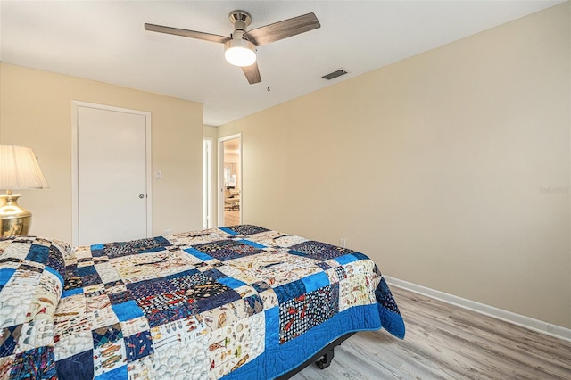 bedroom with a ceiling fan, baseboards, visible vents, and light wood finished floors