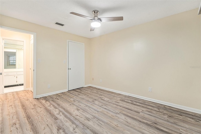 unfurnished bedroom with a textured ceiling, ceiling fan, light wood-style flooring, visible vents, and baseboards