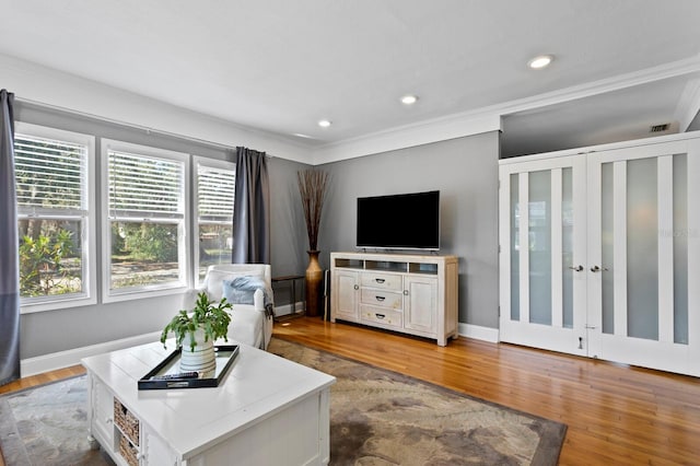 living room with hardwood / wood-style floors and crown molding