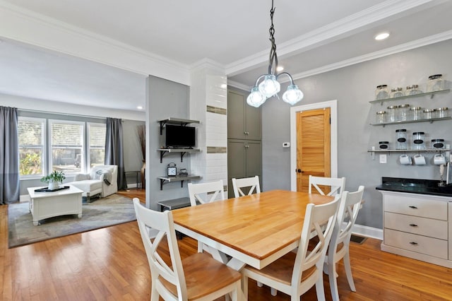 dining area featuring ornamental molding and light wood-type flooring