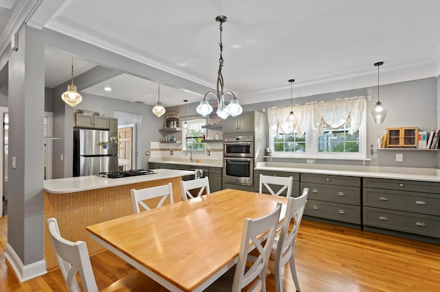 dining space with sink, crown molding, and light hardwood / wood-style floors